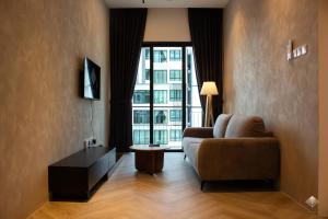 a living room with a couch and a large window at Rumaho Upton by Elica Kuching in Kuching
