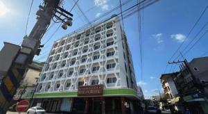 a large white building on the side of a street at Merlin Hotel in Sungai Kolok