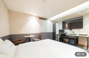 a hotel room with a bed and a desk and a computer at Hotel Cherry in Seoul