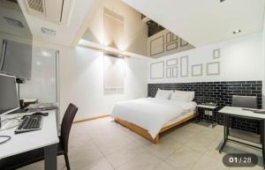 a bedroom with a bed and a desk with a computer at Hotel Cherry in Seoul