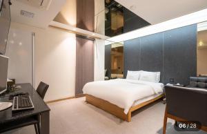 a bedroom with a bed and a desk and a laptop at Hotel Cherry in Seoul