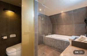 a bathroom with a tub and a toilet and a sink at Hotel Cherry in Seoul