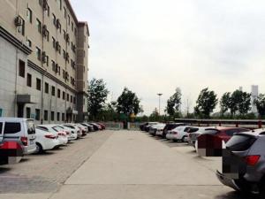 un montón de autos estacionados en un estacionamiento en Jinjiang Inn Bazhou Shengfang Town, en Bazhou