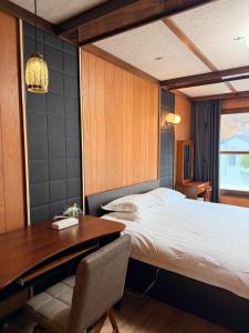 una camera con letto, scrivania, tavolo e sedia di 小樽-Yew Villa a Otaru