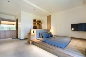 a bedroom with a bed and a flat screen tv at The Rebirth Apartment Binh Chau Ho Tram in Bà Rịa +57 photos