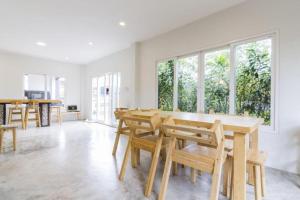 a dining room with a wooden table and chairs at Maximize Brand New Hostel Udonthani in Udon Thani