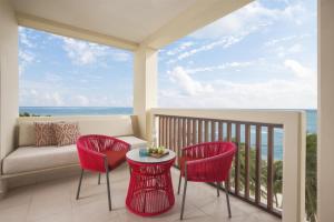 a balcony with a couch and chairs and the ocean at Dreams Puerto Morelos Resort & Spa - All Inclusive in Puerto Morelos +148 photos