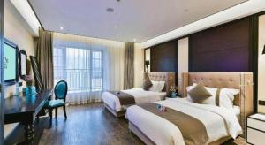 a hotel room with two beds and a desk at Xana Hotelle Chengdu East Railway Station Kaide Plaza in Chengdu