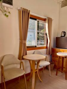 a room with a table and chairs and a window at Rai Boonsom in Phrao
