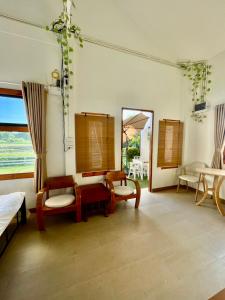 a living room with two chairs and a mirror at Rai Boonsom in Phrao