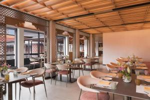 a restaurant with wooden ceilings and tables and chairs at Hilton Hyderabad Genome Valley Resort & Spa in Hyderabad