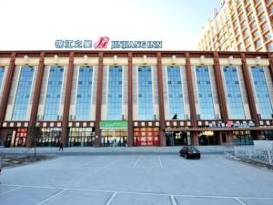 un grand bâtiment avec un parking en face de celui-ci dans l'établissement Jinjiang Inn Daqing Honggang, à Daqing
