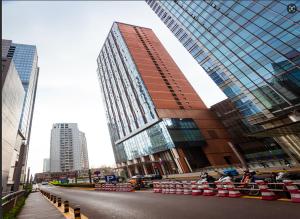 a street in a city with a tall building at Qingdao Tinglan Hotel Apartment (Wusi Square Mixc City Branch) in Fushansuo