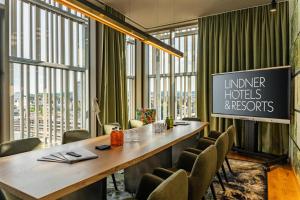 ウルムにあるMe and All Hotel ulm, by Hyattの長いテーブルと椅子のある会議室
