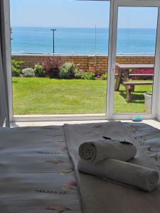 a roll of towels sitting on a rug in front of a window at Bayview Seafront Apartment in Gonubie