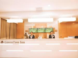 three people sitting at a counter in a waiting room at GreenTree Inn Xi'an Terracotta Warriors Huaqing Pool Metro Station in Xi'an