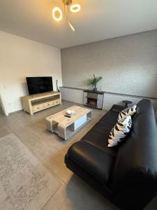 un soggiorno con divano in pelle nera e tavolino da caffè di Fe-Wo B6 1 a Kenn