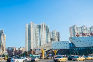 a busy city street with cars in front of tall buildings at 7 Days Inn Harbin West Railway Station in Harbin