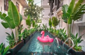 ein Pool mit einem pinkfarbenen aufblasbaren Flamingo in einem Gebäude in der Unterkunft AMANA Boutique Hotel - Thân Văn Nhiếp in Ho-Chi-Minh-Stadt
