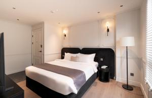 ein Schlafzimmer mit einem großen weißen Bett und einer Lampe in der Unterkunft AMANA Boutique Hotel - Thân Văn Nhiếp in Ho-Chi-Minh-Stadt + 58 Fotos