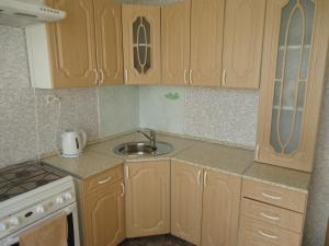 - une cuisine avec des placards en bois et un évier dans l'établissement Apartments on Gagarina 9, à Volgodonsk