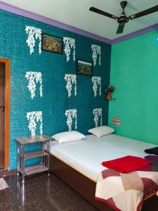 a bedroom with two beds and a green wall at Vinayaka Homestay Hampi in Hampi