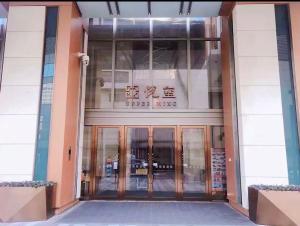 an entrance to a building with glass doors at Qingdao Tinglan Hotel Apartment (Wusi Square Mixc City Branch) in Qingdao +30 photos