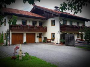 ein großes weißes Haus mit zwei Balkonen darauf in der Unterkunft Ferienwohnung Höfler in Schönau am Königssee