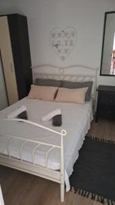 a bedroom with a white bed with two shoes on it at Novalja centar in Novalja