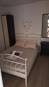 a bedroom with a white bed with a heart on the wall at Novalja centar in Novalja +14 photos