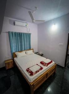 a bedroom with a large bed with a blue curtain at Murdeshwar Savion Homestay in Māvalli