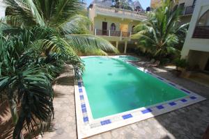 een zwembad voor een huis met palmbomen bij Jannataan Hotel in Lamu