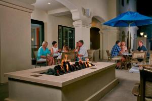 eine Gruppe von Menschen sitzt um ein Feuer in einem Restaurant in der Unterkunft Courtyard by Marriott Anaheim Theme Park Entrance in Anaheim