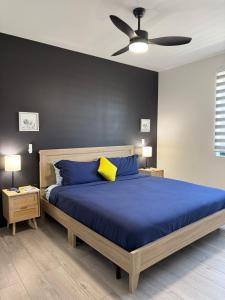 a bedroom with a blue bed with a ceiling fan at OranGe DeLuxe in Omaha