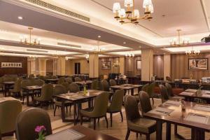 a restaurant with tables and chairs in a room at Jinjiang Metropolo Shanghai Minhang in Shanghai