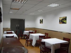 a dining room with white tables and chairs at GreenTree Inn Shanghai Gongkang Road Branch in Jiangwan