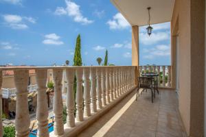 a balcony with a white railing and a table and chairs at Tranquil hideaway with breathtaking sea views in Kissonerga