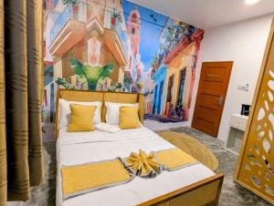 a bedroom with a large bed with a painting on the wall at Bellimena Stone Town in Zanzibar City