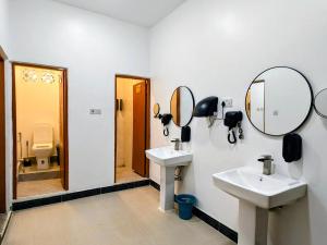 a bathroom with two sinks and mirrors on the wall at Bellimena Stone Town in Zanzibar City +80 photos