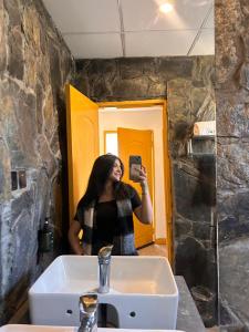 a woman taking a picture of herself in a bathroom mirror at LOKAL Rooms x Skardu (Katpana Retreat) in Skardu