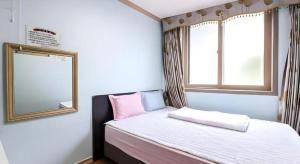 a small bedroom with a bed and a mirror at Ace Hotel in To-dong +85 photos