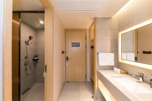 JI Hotel Shanghai North Hi-Tech Industrial Park في شانغهاي: حمام مع حوض ودش