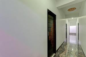 een hal met witte muren en een zwarte deur bij Hotel O R Glory in Khagaul