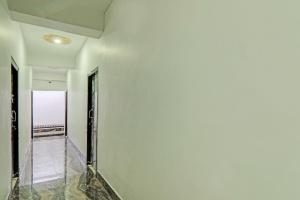 een hal met witte muren en een glazen vloer bij Hotel O R Glory in Khagaul