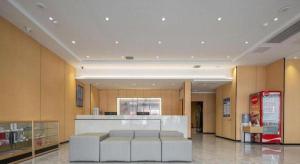 a lobby with a gas station with white stools at GreenTree Inn Anhui Bozhou West Guangming Road Tangwang Avenue Shall Hotel in Bozhou