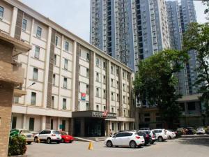 een groot gebouw met auto's geparkeerd op een parkeerplaats bij Jingjiang Inn Xi'an Jianguomen in Xi'an