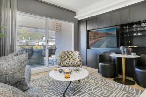 a living room with a couch and a table at Danbury on Loop - Designer Apartment in Cape Town in Cape Town +9 photos