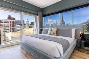 a bedroom with a large bed and a large window at Danbury on Loop - Designer Apartment in Cape Town in Cape Town