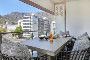 a table on a balcony with a view of a city at Danbury on Loop - Designer Apartment in Cape Town in Cape Town