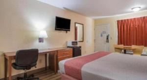 a hotel room with a bed and a desk and a computer at Rodeway Inn & Suites in Lakeview